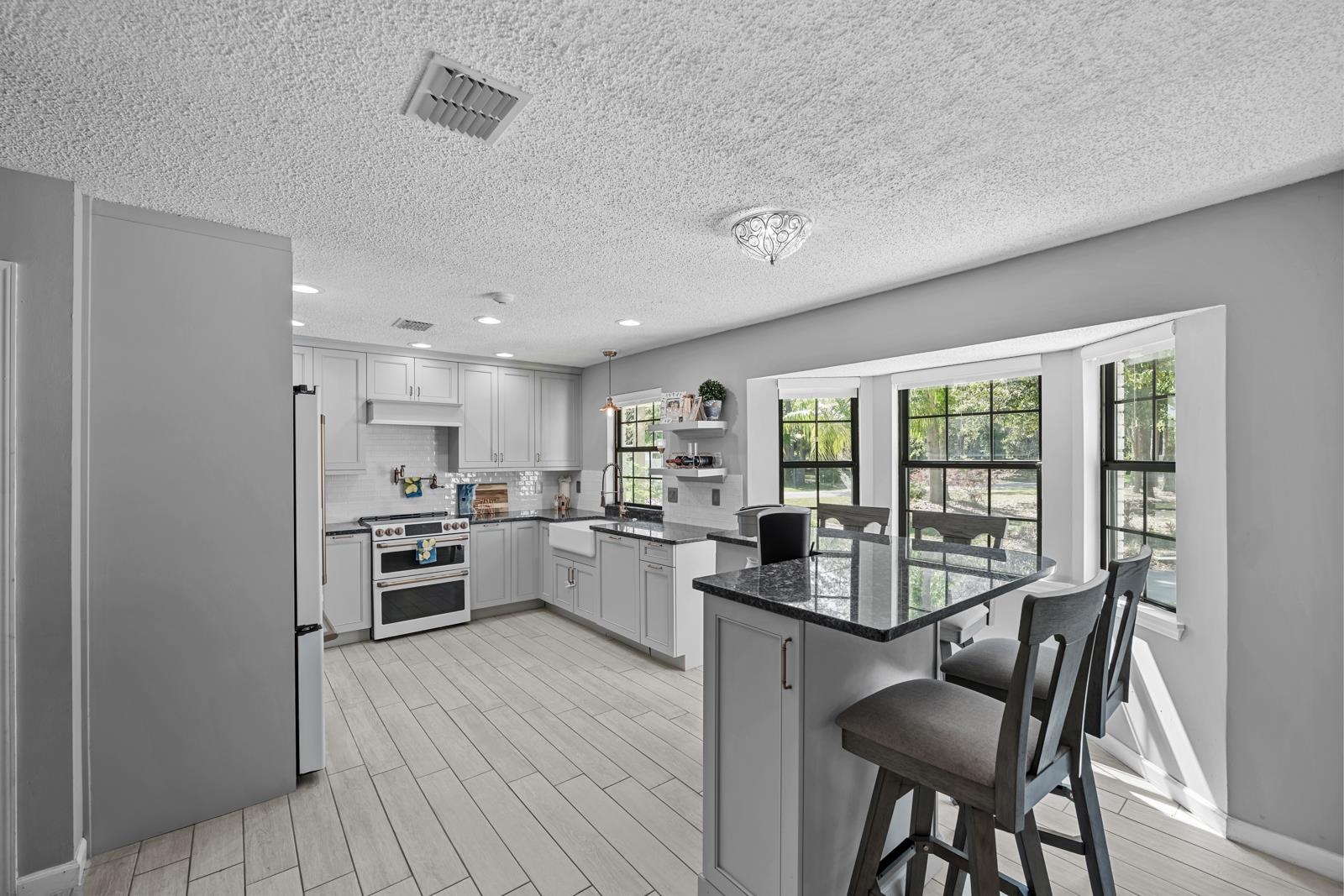 3911 Hillwood Road Jacksonville, FL 32223 - Photo 7 of 33 Kitchen featuring a kitchen bar, range, a wealth of natural light, and light hardwood / wood-style floors