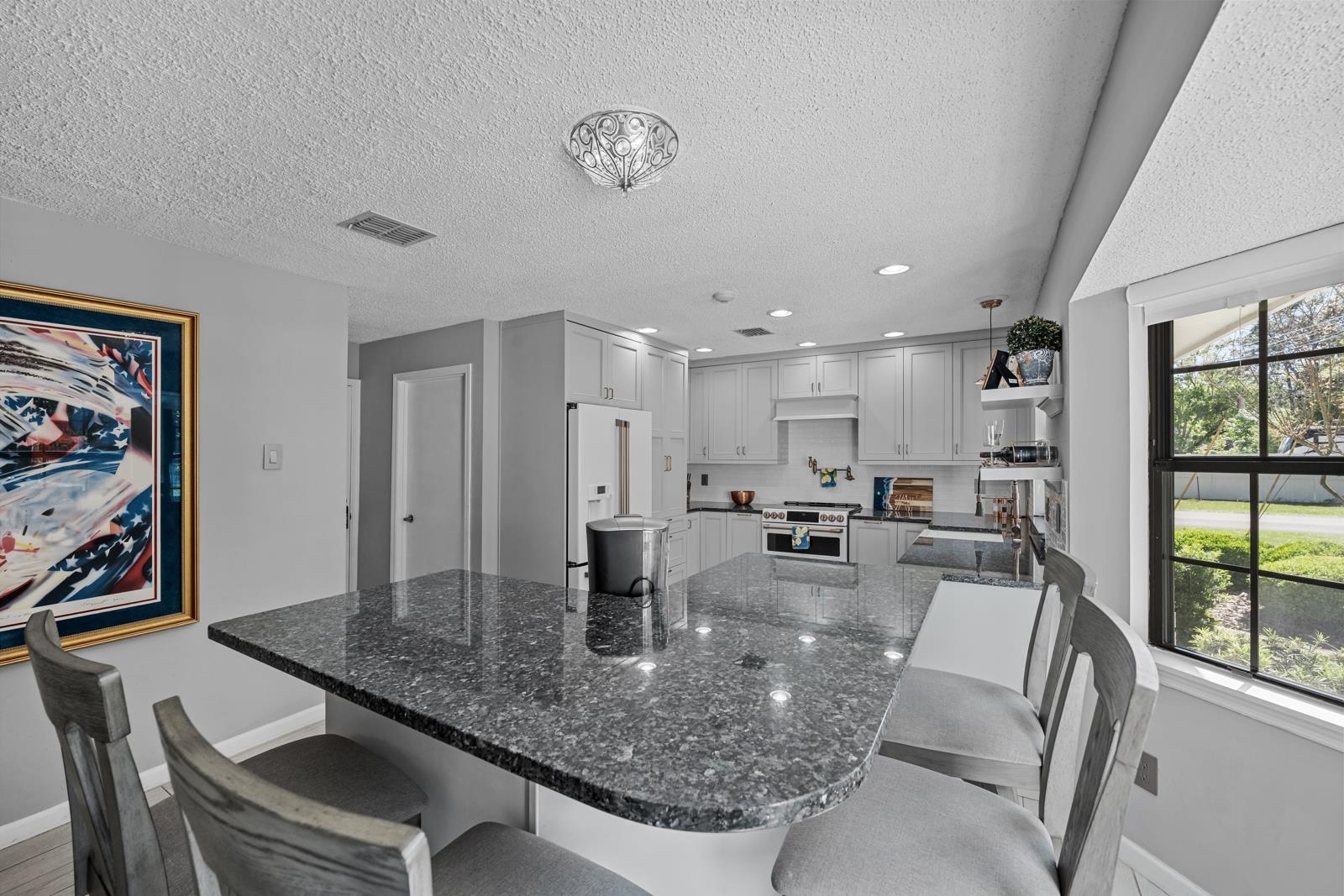 3911 Hillwood Road Jacksonville, FL 32223 - Photo 8 of 33 Kitchen with high end white refrigerator, white cabinets, dark stone countertops, pendant lighting, and a kitchen breakfast bar