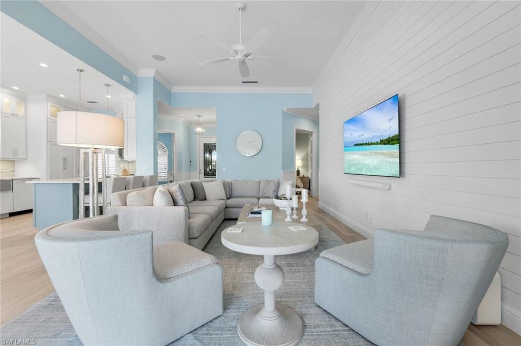 3787 Whidbey Way Naples, FL 34119 - Photo 10 of 50 a living room with couches a mirror and a dining table with wooden floor