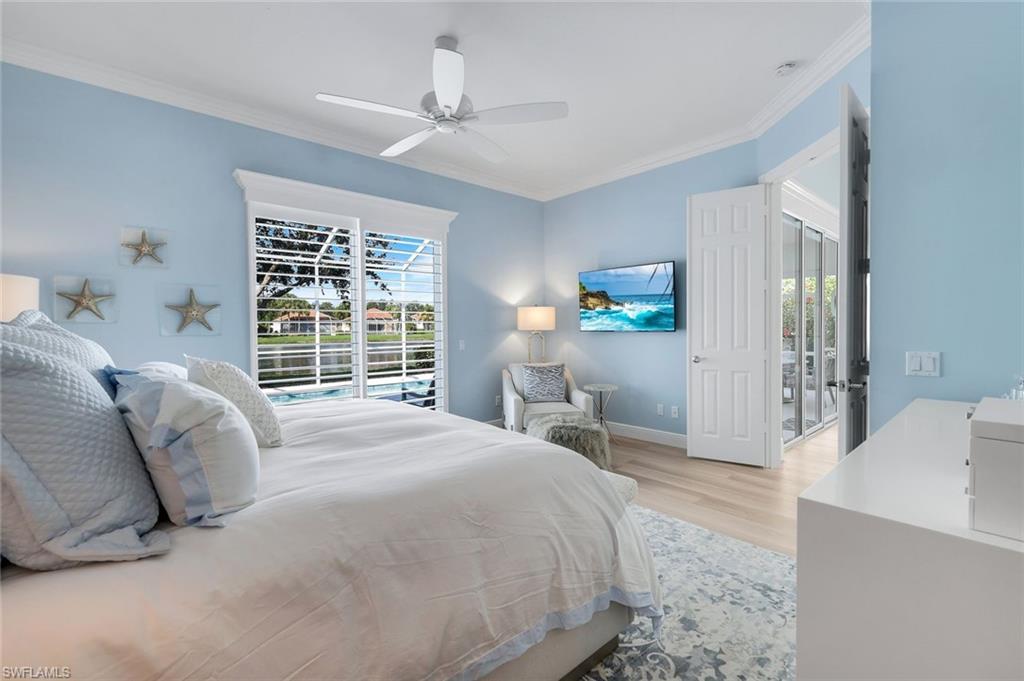3787 Whidbey Way Naples, FL 34119 - Photo 20 of 50 a spacious bedroom with a bed a table and large window