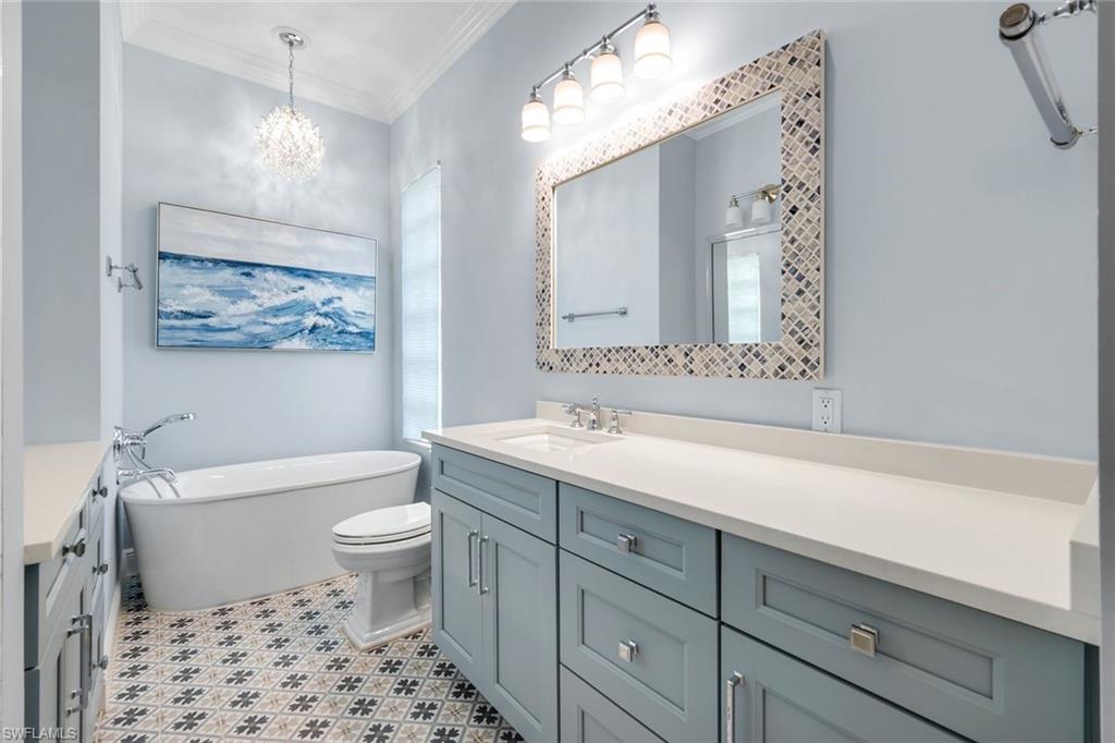 3787 Whidbey Way Naples, FL 34119 - Photo 22 of 50 a bathroom with a sink a toilet a mirror a vanity and bathtub