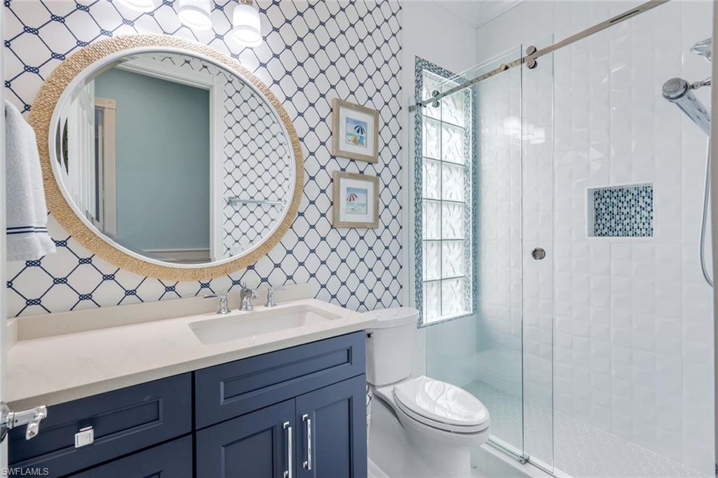 3787 Whidbey Way Naples, FL 34119 - Photo 24 of 50 a bathroom with a sink mirror vanity and toilet