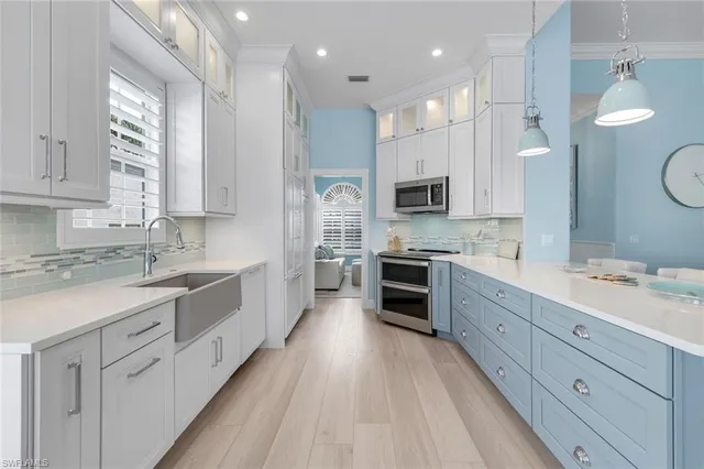 a large kitchen with cabinets stainless steel appliances a sink and a window