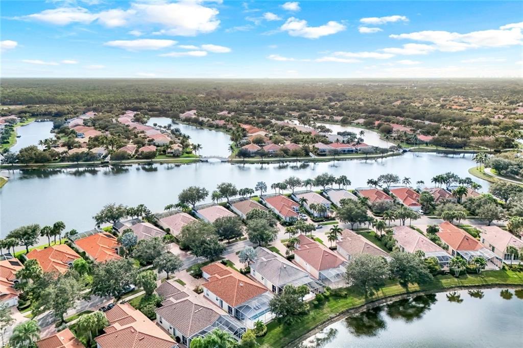 3787 Whidbey Way Naples, FL 34119 - Photo 38 of 50 an aerial view of city and lake with trees all around