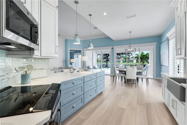 a kitchen with stainless steel appliances granite countertop a sink dishwasher a stove and a microwave oven with wooden floor