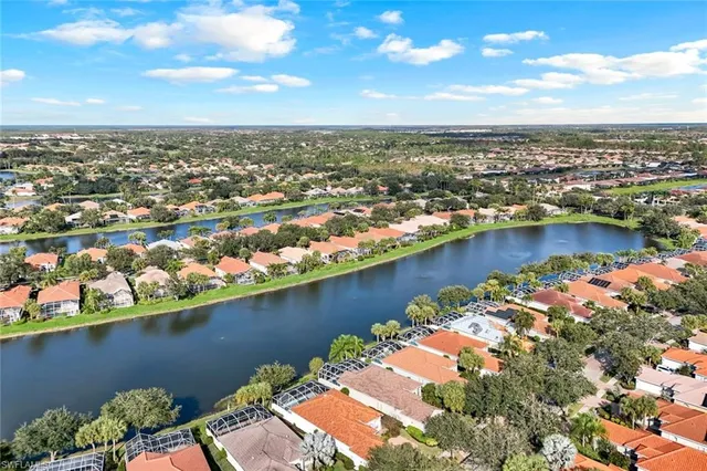 an aerial view of city and lake with trees all around