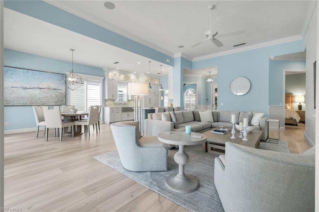 3787 Whidbey Way Naples, FL 34119 - Photo 9 of 50 a living room with couches chairs and kitchen view with wooden floor