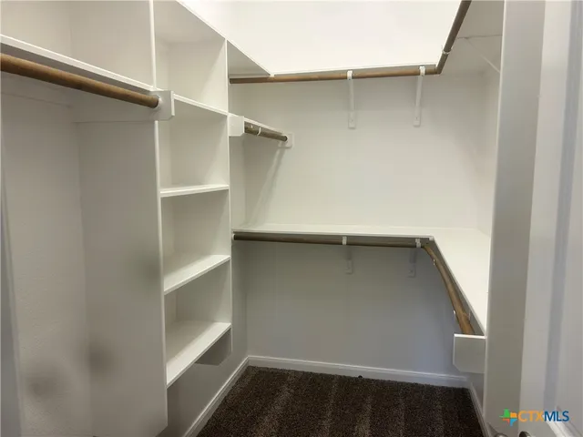 a view of walk in closet with empty racks