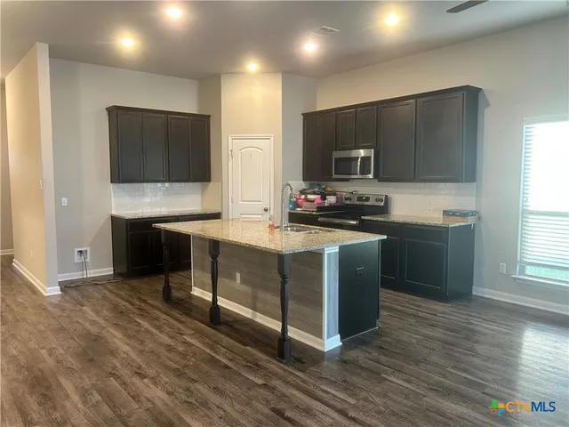 a kitchen with stainless steel appliances a stove a sink and a refrigerator