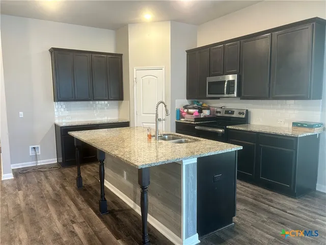 a kitchen with sink cabinets and microwave