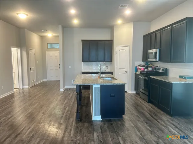 a kitchen with a sink stove and cabinets