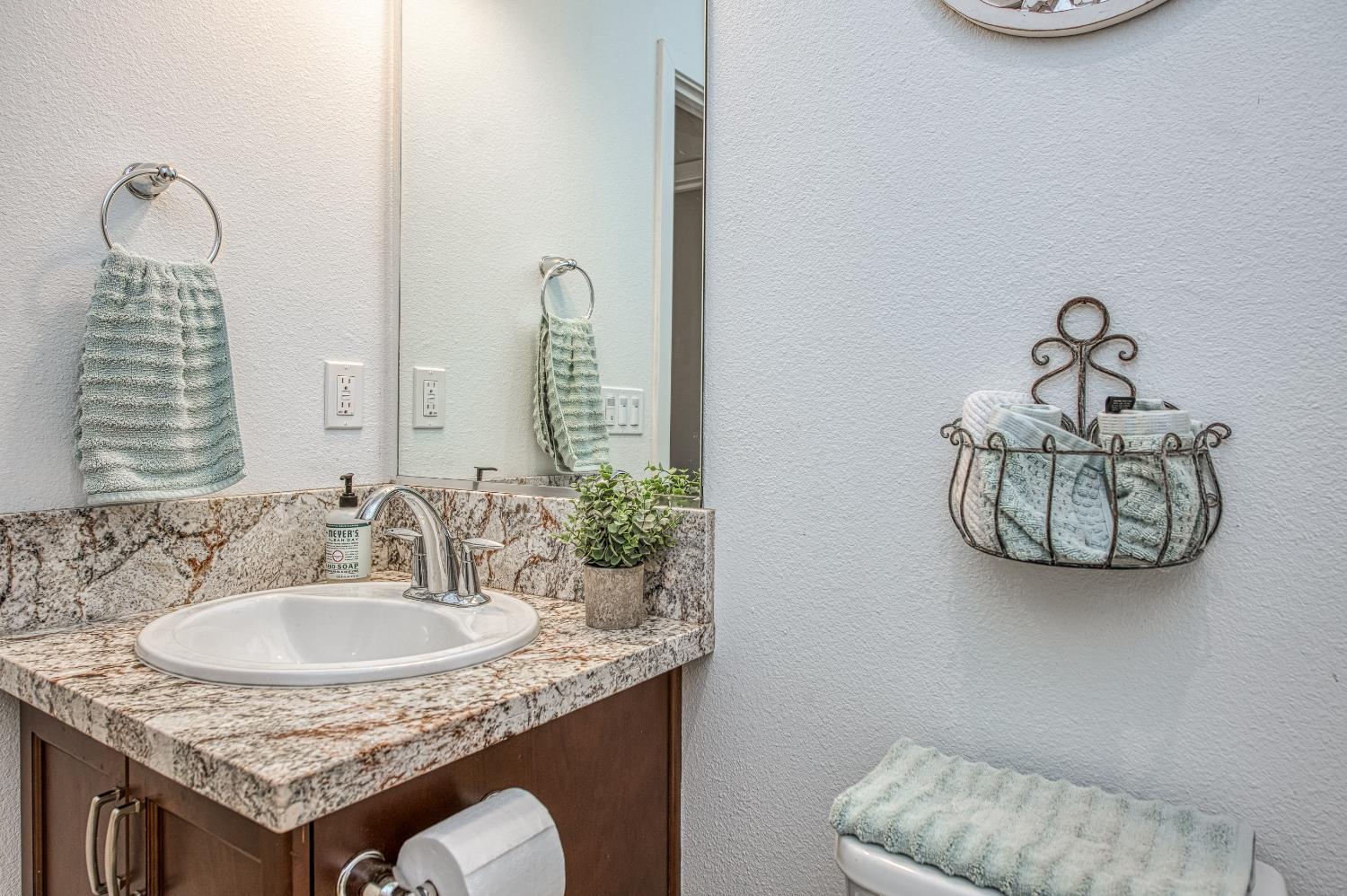 4534 Hillside Road Madera, CA 93636 - Photo 17 of 92 a bathroom with a granite countertop sink and a mirror