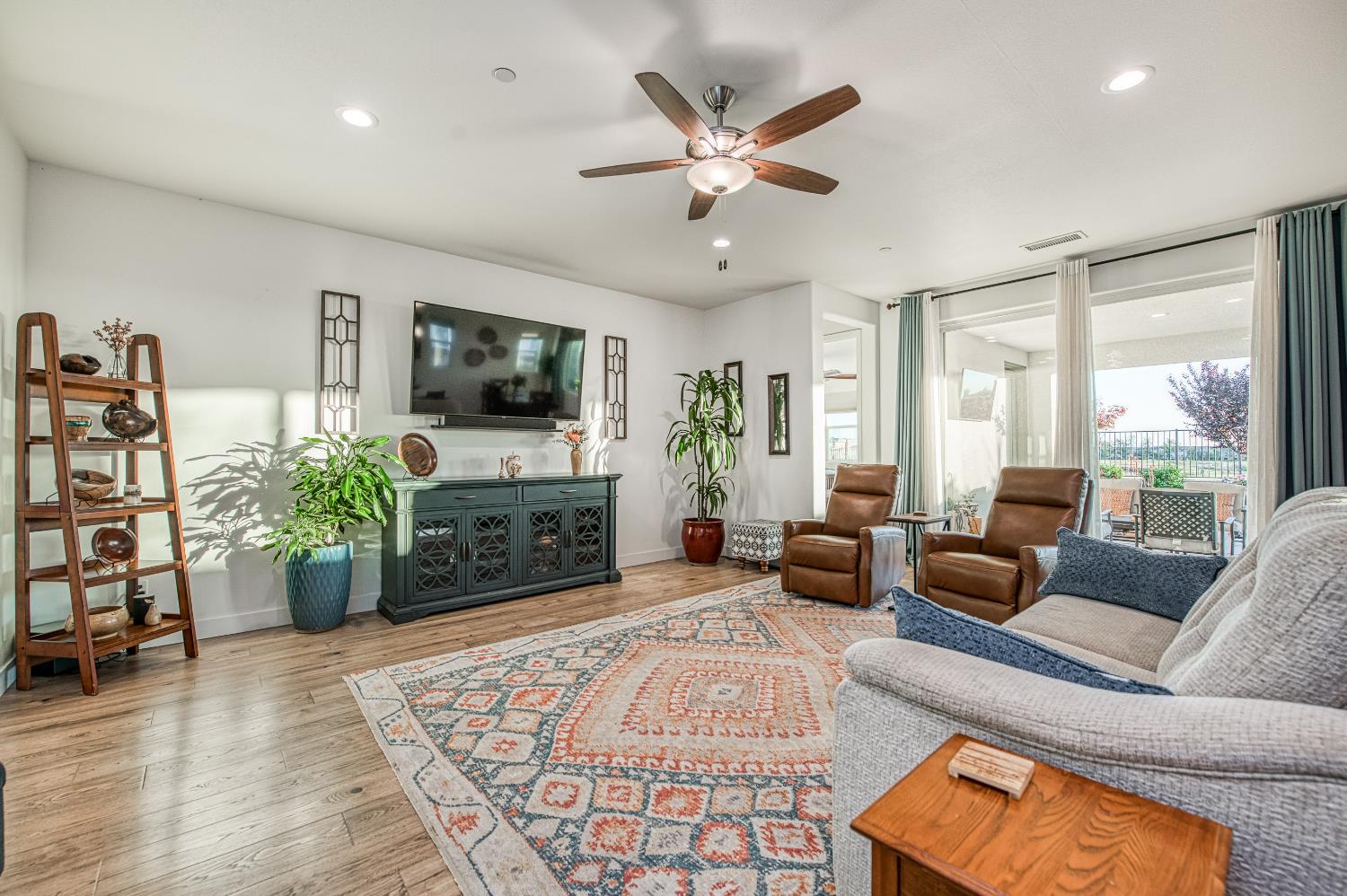 4534 Hillside Road Madera, CA 93636 - Photo 27 of 92 a living room with furniture a flat screen tv and a large window