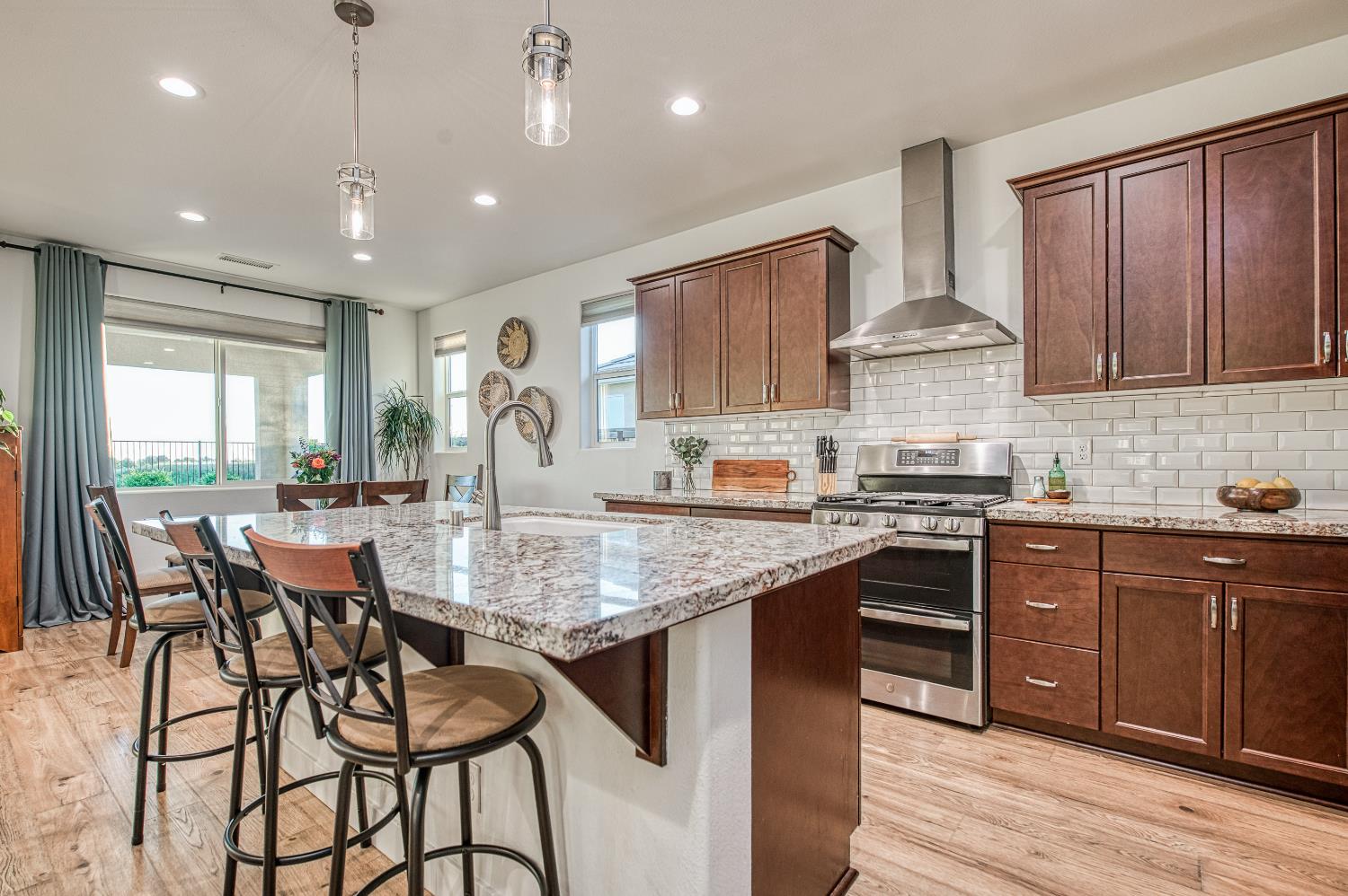 4534 Hillside Road Madera, CA 93636 - Photo 32 of 92 a kitchen with stainless steel appliances granite countertop wooden cabinets a center island and a window