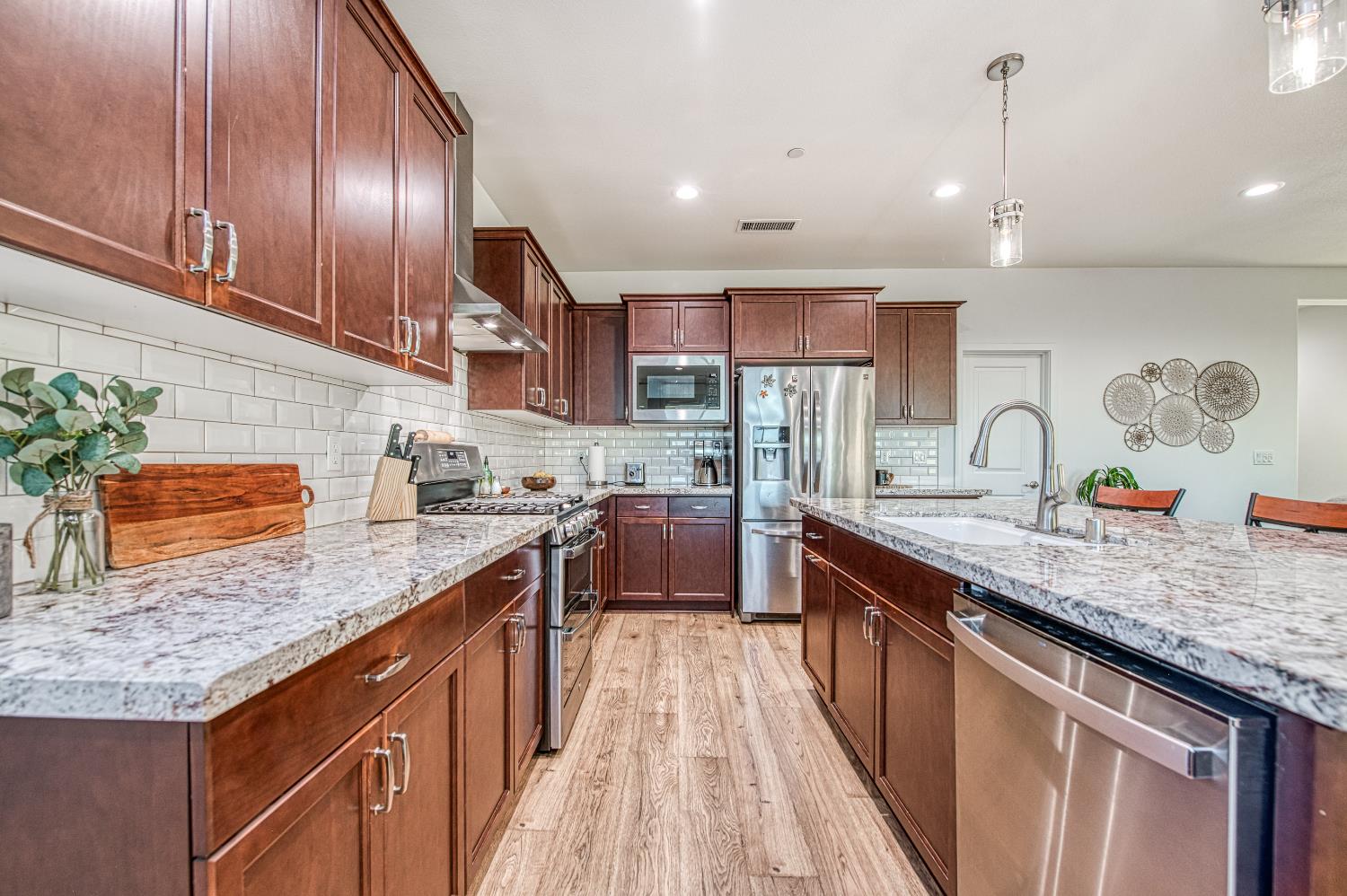 4534 Hillside Road Madera, CA 93636 - Photo 36 of 92 a kitchen with stainless steel appliances granite countertop a sink stove and cabinets