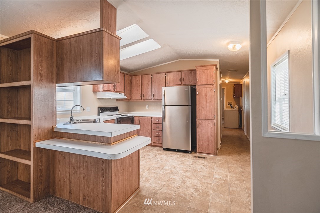 4727 Owens Road Northeast, Unit 20 Moses Lake, WA 98837 - Photo 13 of 36 a kitchen with stainless steel appliances granite countertop a refrigerator a stove and a sink
