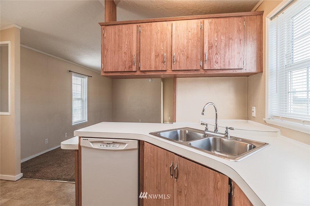 4727 Owens Road Northeast, Unit 20 Moses Lake, WA 98837 - Photo 15 of 36 a kitchen with stainless steel appliances granite countertop a sink a microwave cabinets and a window