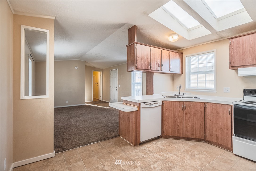 4727 Owens Road Northeast, Unit 20 Moses Lake, WA 98837 - Photo 17 of 36 a kitchen with granite countertop a sink stove and cabinets