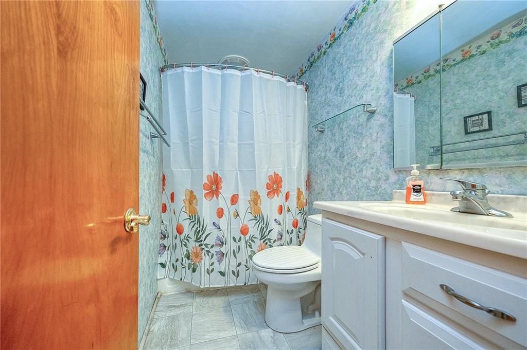 609 Regency Drive Pittsburgh, PA 15239 - Photo 26 of 32 a bathroom with a shower curtain sink and a toilet