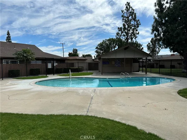 a view of a house with pool and a yard in front of it