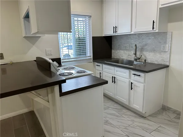 a kitchen with cabinets appliances and a sink