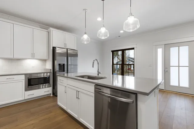 a kitchen with granite countertop white cabinets and stainless steel appliances
