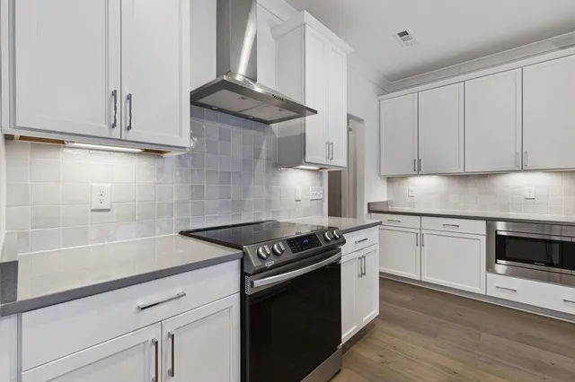 a kitchen with stainless steel appliances granite countertop a stove and a sink
