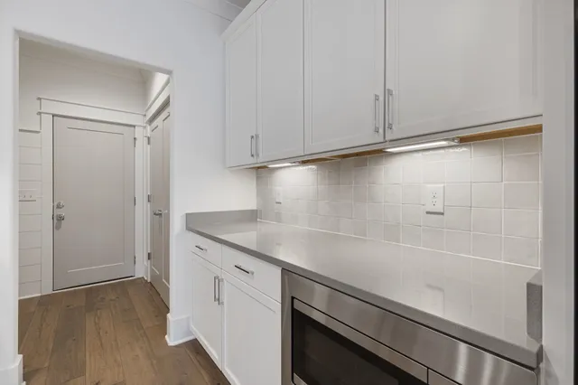 a kitchen with stainless steel appliances a stove and wooden floor