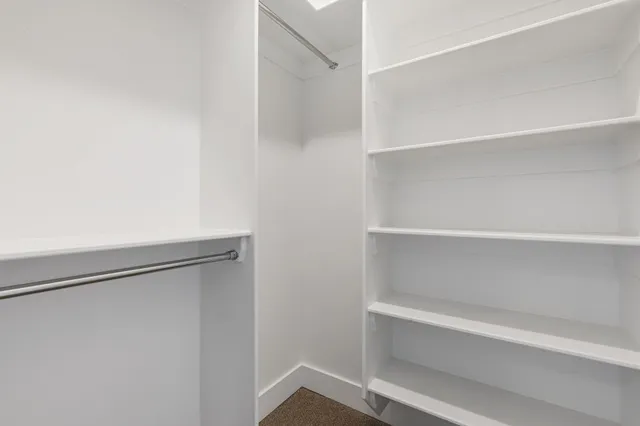 an empty room with a chandelier fan