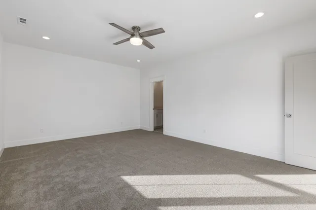 an empty room with fan and windows