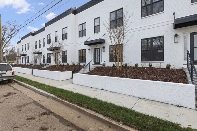 an open kitchen with white cabinets wooden floor and a window