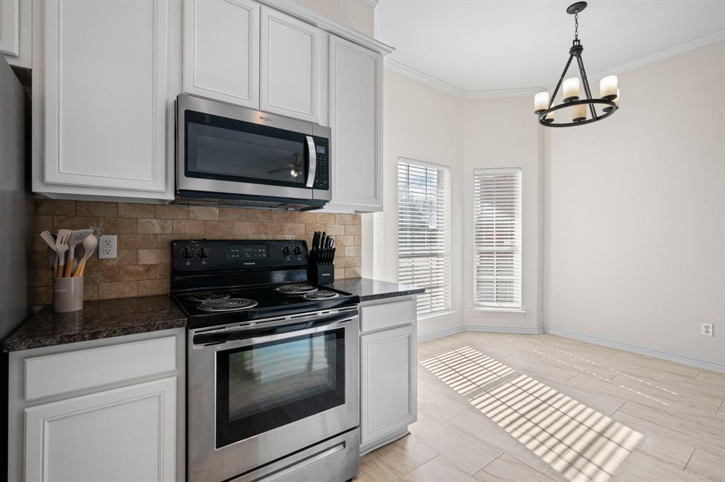 7 St Charles Place Midlothian, TX 76065 - Photo 12 of 27 a kitchen with stainless steel appliances a stove a microwave and cabinets