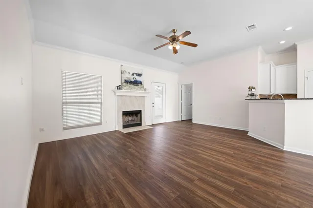 a view of empty room with wooden floor and fireplace