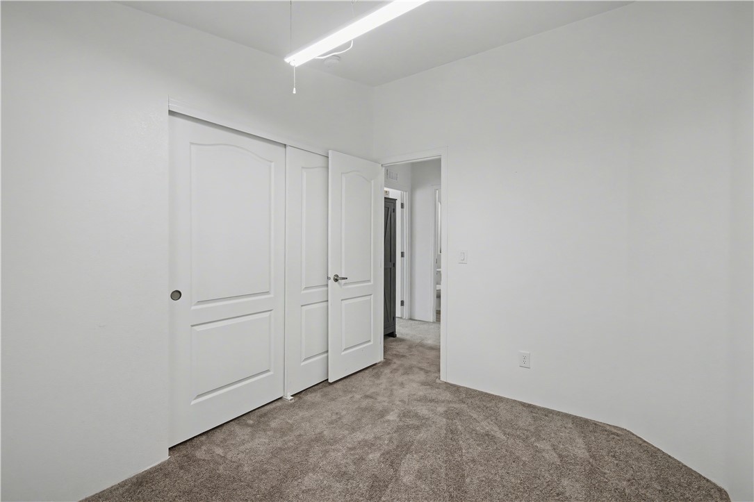 3058 West Carmichael Road Golden Valley, AZ 86413 - Photo 10 of 36 Unfurnished bedroom with carpet floors and a closet