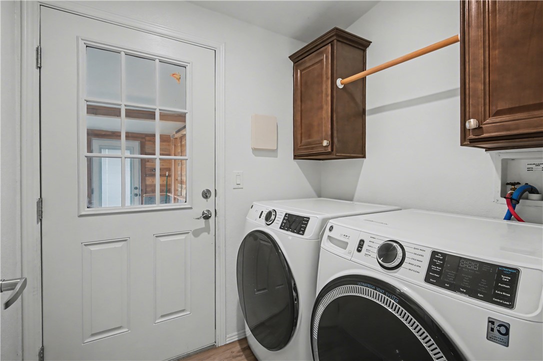 3058 West Carmichael Road Golden Valley, AZ 86413 - Photo 17 of 36 Laundry room featuring washer and clothes dryer, cabinet space, and light wood-style flooring