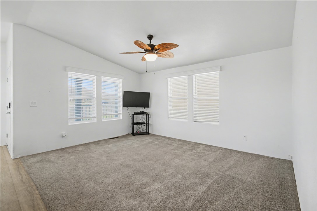 3058 West Carmichael Road Golden Valley, AZ 86413 - Photo 3 of 36 Unfurnished living room featuring vaulted ceiling and a ceiling fan