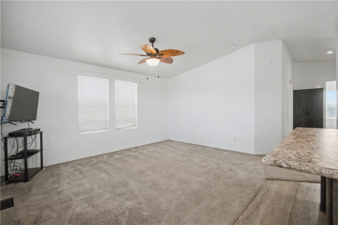 3058 West Carmichael Road Golden Valley, AZ 86413 - Photo 5 of 36 Unfurnished living room featuring ceiling fan and light carpet