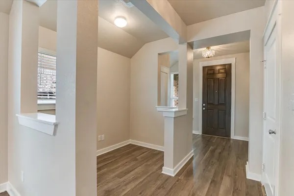 a view of a hallway with wooden floor and closet