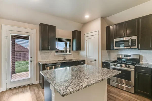 a view of a kitchen with a sink a refrigerator and window