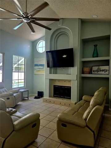 a living room with furniture a flat screen tv and a fireplace