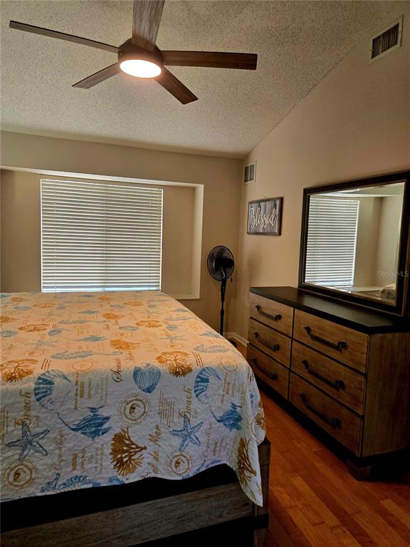 7838 Trail Run Loop New Port Richey, FL 34653 - Photo 17 of 36 a bedroom with a bed and a flat tv screen on dresser