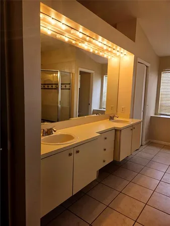 a spacious bathroom with a double vanity sink and a mirror