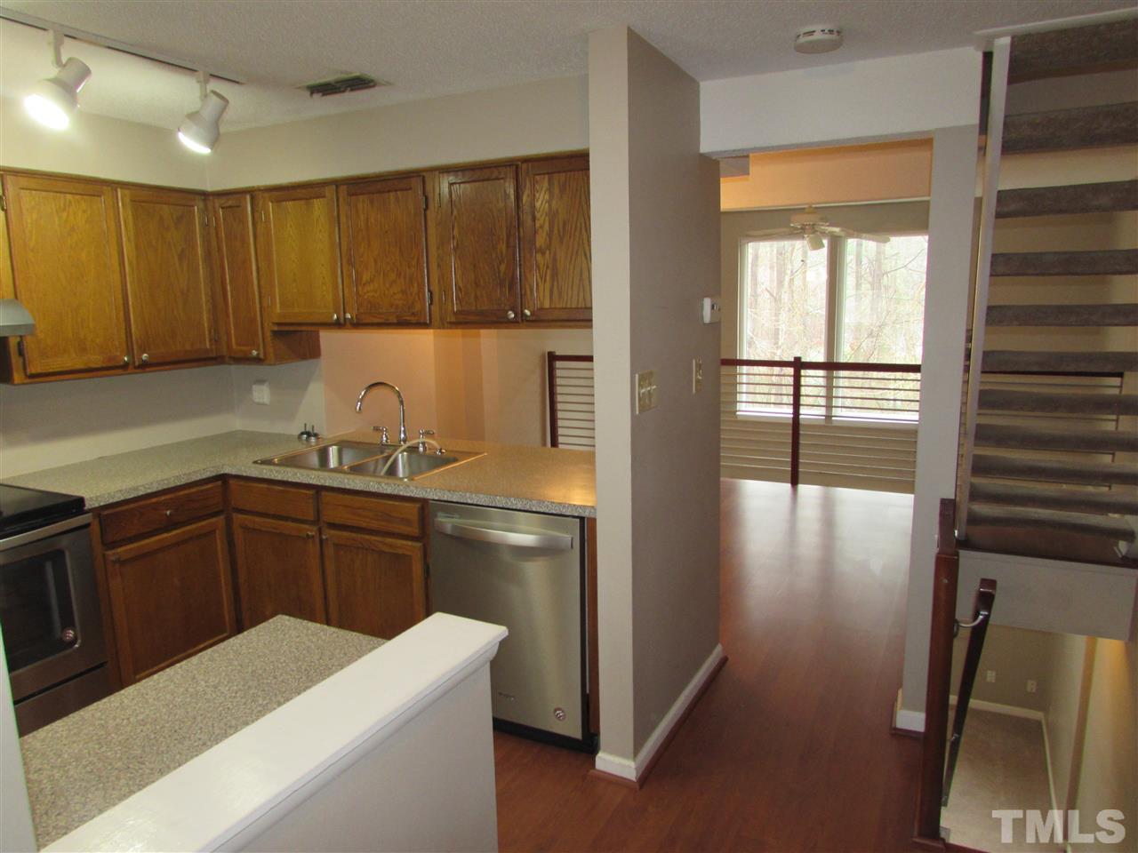 7750 Sandra Lane Raleigh, NC 27615 - Photo 2 of 25 a kitchen with a refrigerator and wooden cabinets