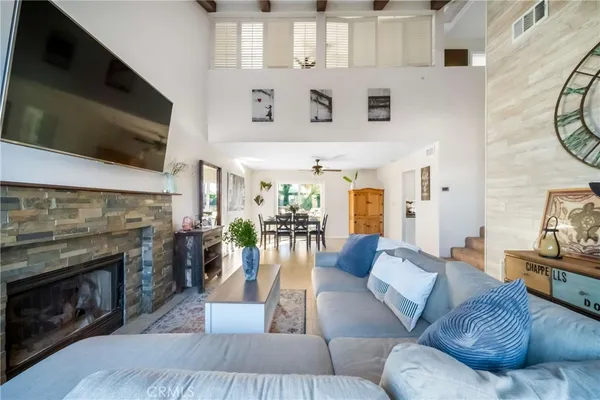 a living room with furniture a flat screen tv and a fireplace