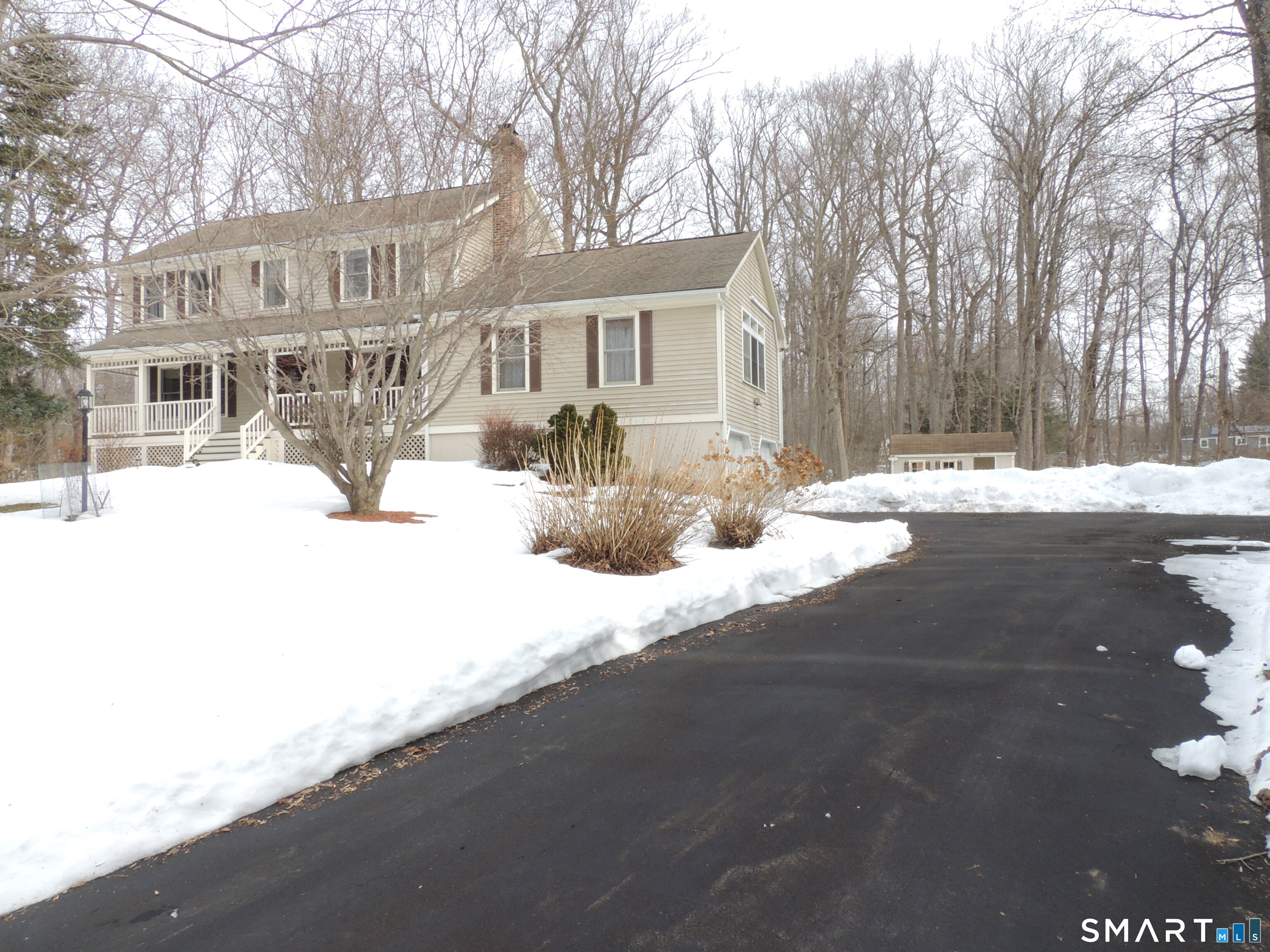 a front view of a house with a yard covered in snow