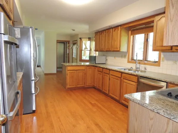 a kitchen with stainless steel appliances granite countertop a sink stove and refrigerator