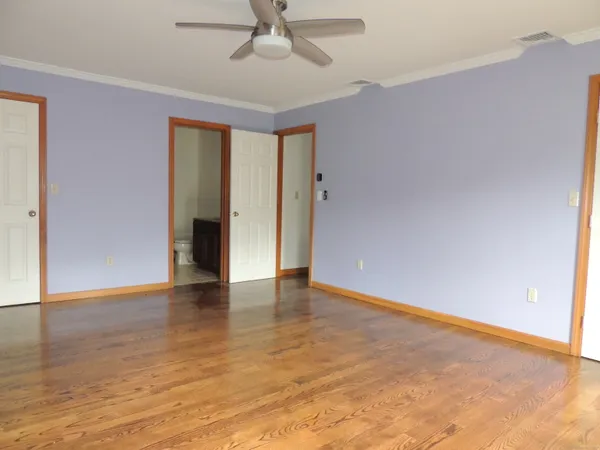 an empty room with wooden floor and natural light