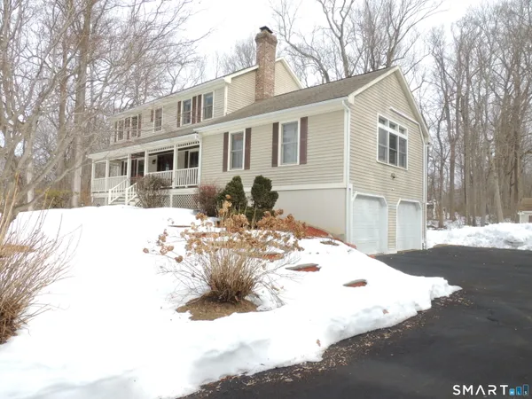 a front view of a house with a yard covered in snow
