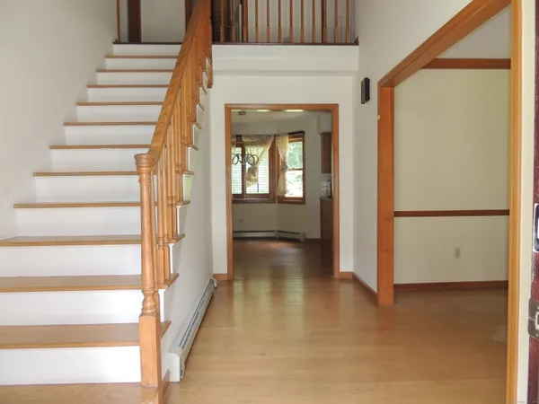 a view of a hallway with wooden floor and entryway