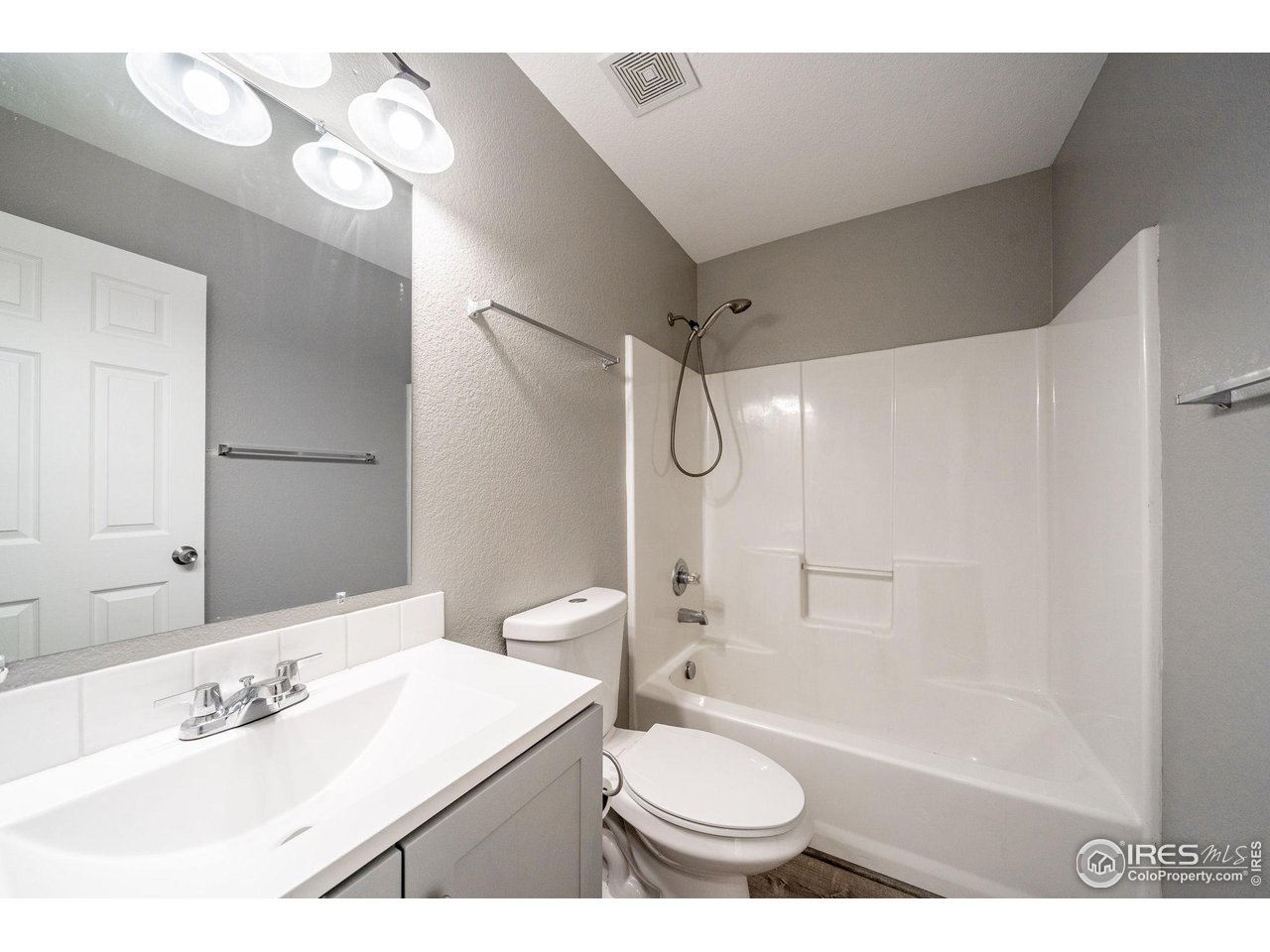 1021 East 25th St Road Greeley, CO 80631 - Photo 16 of 22 a bathroom with a sink a toilet a mirror and shower